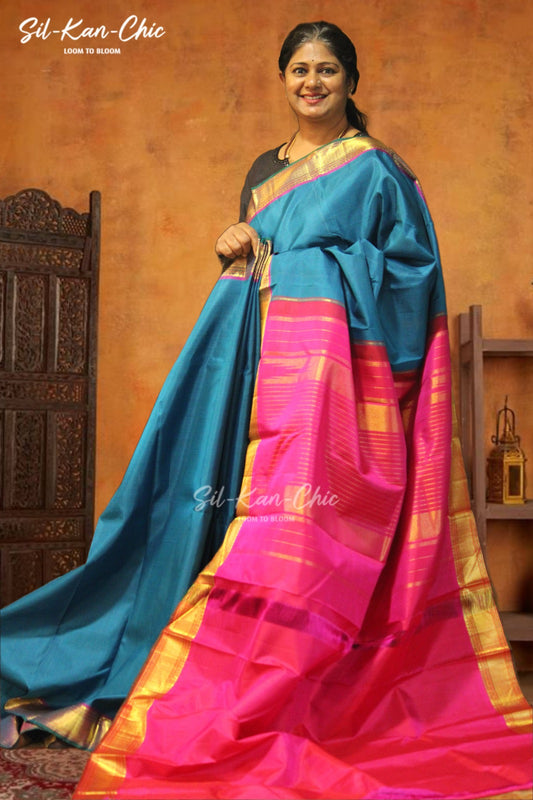 Blue with tiny checks in the body with gold zari bavanji border and a green selvage Rani pink contrast pallu and blouse Kanchipuram Silk Saree